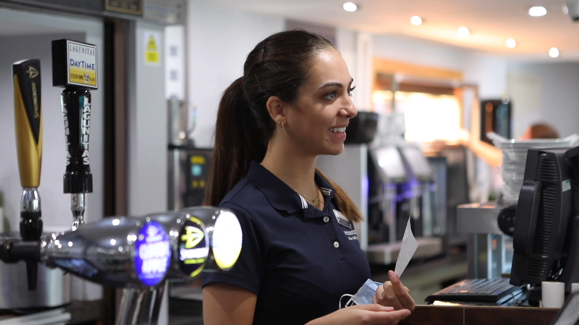female bar staff member smiling at customer