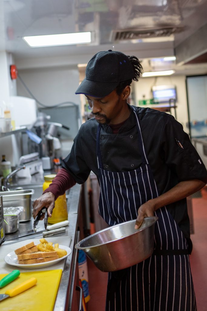 chef carefully preparing food in apron at golf club